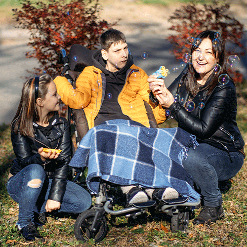 Family enjoying time outdoors with a young person using a wheelchair, representing inclusive disability and continence support services in Broadmeadows, Vic.