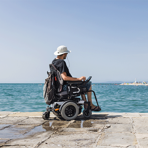 Person in a powered wheelchair looking out over the water, continence assessment in Revesby, NSW